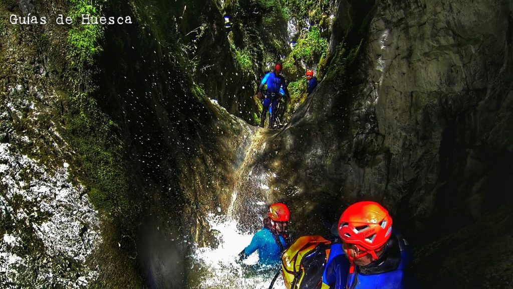 Grupo de barranquistas disfrutando en un tobogán del barranco de las Gloces en el Pirineo Aragonés